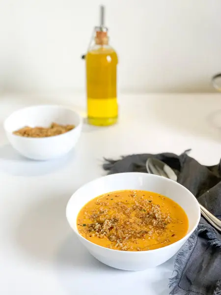 Kıtır kıtır süslerle süslenmiş canlı bir kase kremalı çorba sağlıklı yemekler için ideal hale getiriyor.