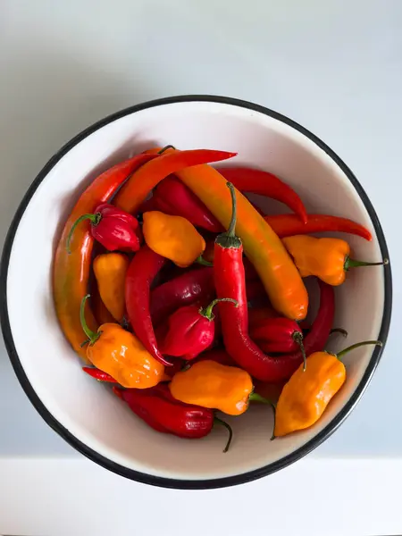 Canlı ve renkli bir biber çeşidi bir kasede güzelce sergileniyor, zengin renklerini sergiliyor.