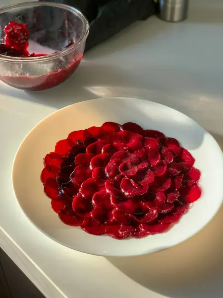 Gül desenli güzel bir pancar salatası. Beyaz bir tabakta canlı renkler sergiliyor..