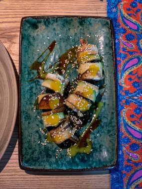 Lezzetli bir suşi sarması sunumu canlı ve renkli soslar ve lezzetli malzemelerle birlikte.