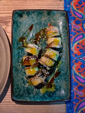 Lezzetli bir suşi sarması sunumu canlı ve renkli soslar ve lezzetli malzemelerle birlikte.