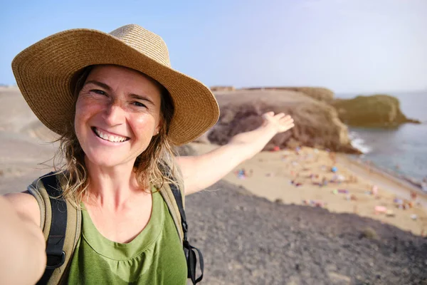 Kadın turist, arka planda, Kanarya Adaları 'nda ünlü Papagayo plajıyla selfie çekiyor ve selfie çekiyor..