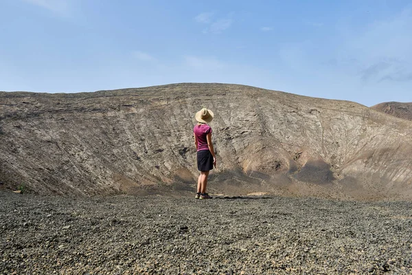 一个戴帽子的女人看着兰萨罗特火山的火山口 加那利群岛 西班牙 — 图库照片