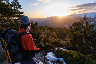 Gün doğumunda bir dağcının arka görüntüsü..