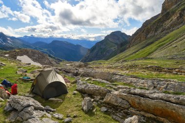 Kayalık bir dağın eteklerine kurulmuş yeşil çadır ana kampın keyfini çıkarıyor. Aragonlu Pireneler