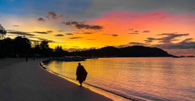 Monk walking at sunrise on Pattaya Beach in Koh Lipe, Satun, Thailand, south east asia