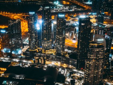 Aerial view of Downtown Dubai with roads, Dubai Mall and the fountain by night, from Burj Khalifa observatory deck in United Arab Emirates. High quality photo
