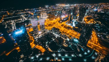 Aerial view of Downtown Dubai with roads, Dubai Mall and the fountain by night, from Burj Khalifa observatory deck in United Arab Emirates. High quality photo