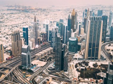 Aerial view of Downtown Dubai with roads, Dubai Mall and the fountain at sunrise, from Burj Khalifa observatory deck in United Arab Emirates. High quality photo