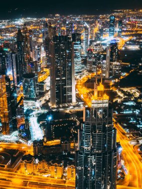Aerial view of Downtown Dubai with roads, Dubai Mall and the fountain by night, from Burj Khalifa observatory deck in United Arab Emirates. High quality photo