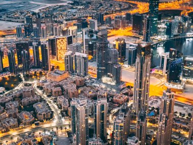 Aerial view of Downtown Dubai with roads, Dubai Mall and the fountain at sunrise, from Burj Khalifa observatory deck in United Arab Emirates. High quality photo