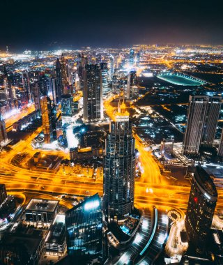 Aerial view of Downtown Dubai with roads, Dubai Mall and the fountain by night, from Burj Khalifa observatory deck in United Arab Emirates. High quality photo