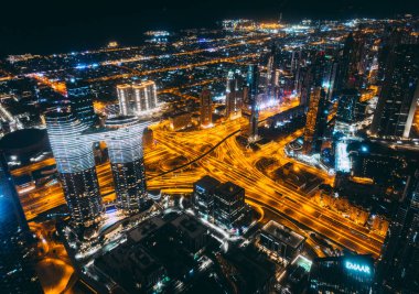 Aerial view of Downtown Dubai with roads, Dubai Mall and the fountain by night, from Burj Khalifa observatory deck in United Arab Emirates. High quality photo