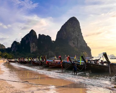 Uzun kuyruklu tekneler gün batımında Krabi, Tayland, Güney Asya 'daki Railay plajında
