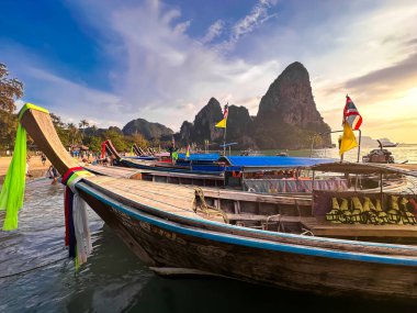 Uzun kuyruklu tekneler gün batımında Krabi, Tayland, Güney Asya 'daki Railay plajında