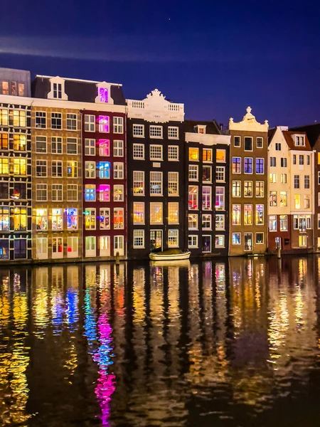 Damrak narrow houses at night in Amsterdam center, Netherlands. High quality photo