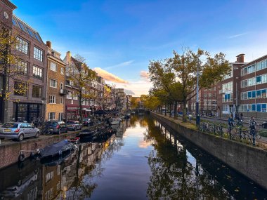 Hollanda 'da günbatımında tekne ve bisikletlerle Amsterdam kanal manzarası. Yüksek kalite fotoğraf
