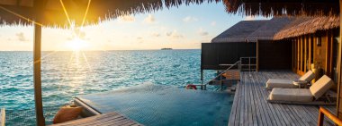 Maldivler 'deki su üstü havuz villasından gün batımı manzarası. Yüksek kalite fotoğraf