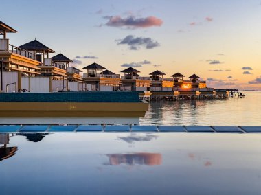 Maldivler 'deki su üstü havuz villasından gün batımı manzarası. Yüksek kalite fotoğraf
