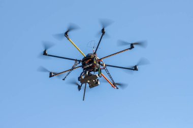 industrial drone with a video camera on a background of blue sky clipart