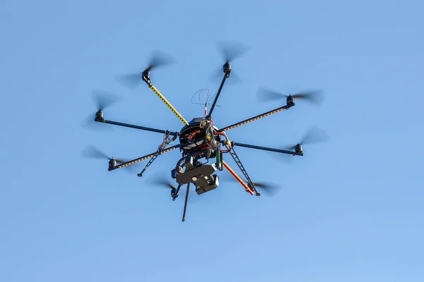 蓝天背景下配备摄像机的工业无人机 免版税图库照片