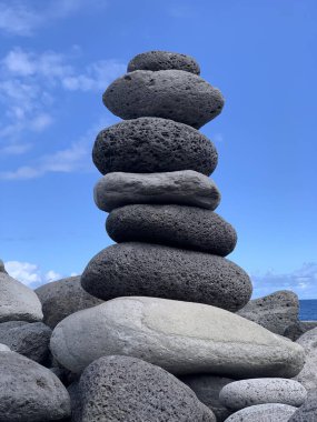 Mavi gökyüzüne karşı kıyıda kairn yakın çekim, denge