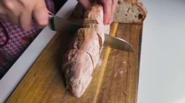 Kadın elleri kesme tahtasında ekmek dilimliyor, yakın çekim, yavaş çekim, 4k