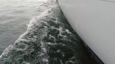Yatın güvertesinden pruvaya kadar, yakın çekim. Yeşil deniz ve dalgaların yan görüntüsü. Kavram, yaşam tarzı ve özgürlük. Yavaş çekim