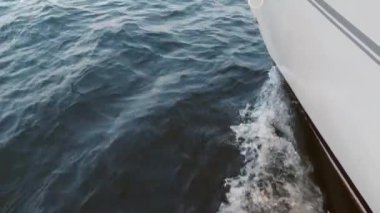 Yatın güvertesinden pruvaya kadar, yakın çekim. Yeşil deniz ve dalgaların yan görüntüsü. Kavram, yaşam tarzı ve özgürlük. Yavaş çekim