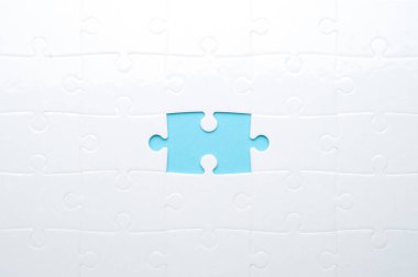 Beyaz yapboz, parlak mavi bir arka planda, bir parça eksik. Sorun çözme, takım çalışması, çözümler ya da eksik bağlantılar kavramı. Kopyalama alanı olan minimalist kompozisyon.