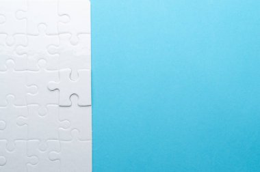 Beyaz yapboz, parlak mavi bir arka planda, bir parça eksik. Sorun çözme, takım çalışması, çözümler ya da eksik bağlantılar kavramı. Kopyalama alanı olan minimalist kompozisyon.