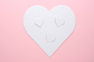 Beyaz kalp şeklinde yapboz. Gri bir arka planda. Birkaç parça kayıp ve yakınlarda. Aşkı, bağlantıyı ya da eksikliği simgeleyen, ilişkiler ve duygular için mükemmel.