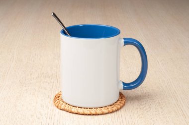 Yeşil saplı ve iç kısımlı kupa. Kaşıklı kupa, tarçın, yıldız anason. Masadaki bardak altlığında iki tonluk bir bardak..