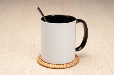 Yeşil saplı ve iç kısımlı kupa. Kaşıklı kupa, tarçın, yıldız anason. Masadaki bardak altlığında iki tonluk bir bardak..