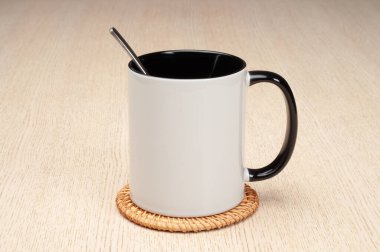 Yeşil saplı ve iç kısımlı kupa. Kaşıklı kupa, tarçın, yıldız anason. Masadaki bardak altlığında iki tonluk bir bardak..