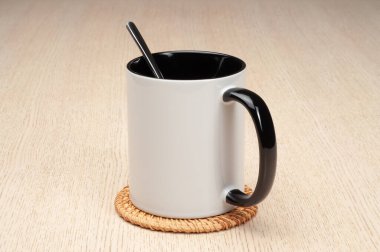 Yeşil saplı ve iç kısımlı kupa. Kaşıklı kupa, tarçın, yıldız anason. Masadaki bardak altlığında iki tonluk bir bardak..