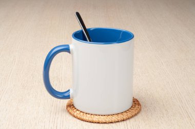 Yeşil saplı ve iç kısımlı kupa. Kaşıklı kupa, tarçın, yıldız anason. Masadaki bardak altlığında iki tonluk bir bardak..