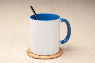 Yeşil saplı ve iç kısımlı kupa. Kaşıklı kupa, tarçın, yıldız anason. Masadaki bardak altlığında iki tonluk bir bardak..