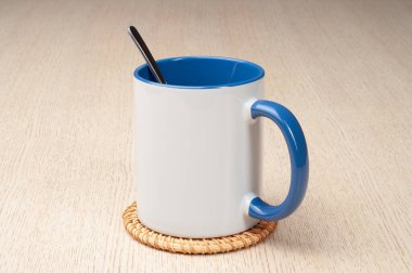 Yeşil saplı ve iç kısımlı kupa. Kaşıklı kupa, tarçın, yıldız anason. Masadaki bardak altlığında iki tonluk bir bardak..