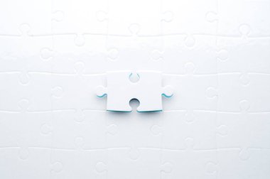 Beyaz yapboz, parlak mavi bir arka planda, bir parça eksik. Sorun çözme, takım çalışması, çözümler ya da eksik bağlantılar kavramı. Kopyalama alanı olan minimalist kompozisyon.