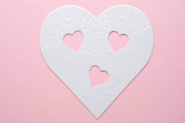 Beyaz kalp şeklinde yapboz. Gri bir arka planda. Birkaç parça kayıp ve yakınlarda. Aşkı, bağlantıyı ya da eksikliği simgeleyen, ilişkiler ve duygular için mükemmel.