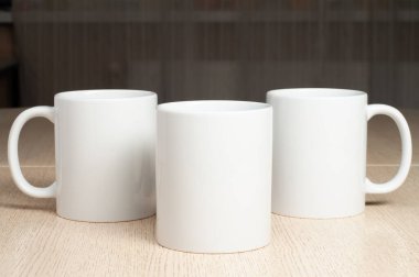 Masada üç tane boş 11ons beyaz bardak var. Kupalar maketi