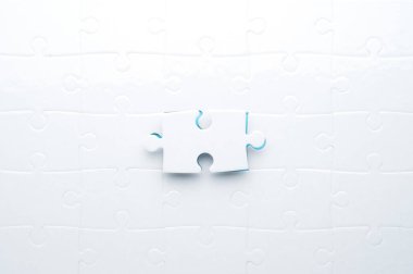 Beyaz yapboz, parlak mavi bir arka planda, bir parça eksik. Sorun çözme, takım çalışması, çözümler ya da eksik bağlantılar kavramı. Kopyalama alanı olan minimalist kompozisyon.