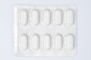 Beyaz arka planda bir hap paketinin üst görüntüsü. Tıbbi, eczane, sağlık ve ilaç tasarımı, stok resimleri ve sağlıkla ilgili sunumlar için ideal.