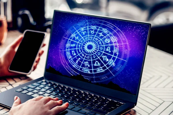 Astrological forecast for the zodiac signs. Woman sitting in cafe with open laptop with a picture of the zodiac circle. school of astrology. Forecast for the future