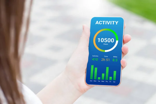woman using activity tracking app on mobile phone. app design by number of steps per day