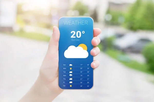 天気予報モバイルアプリケーション 女性の手は木の背景を持つ公園でその日の天気予報と携帯電話を保持しています 暖かい夏の春 — ストック写真