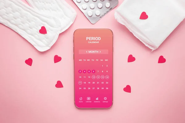 Menstrual cycle mobile app on smartphone screen on a pink background. top view. pregnancy planning