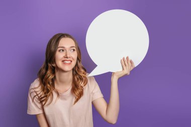 Ukraynalı öğrenci elinde beyaz kâğıt konuşma balonu tutuyor. Mor arka planda izole edilmiş tişört giydiğini düşünüyor.