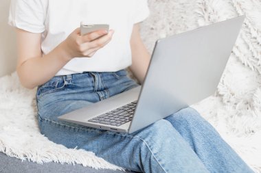 Dizüstü bilgisayarı ve cep telefonu olan bir kız.